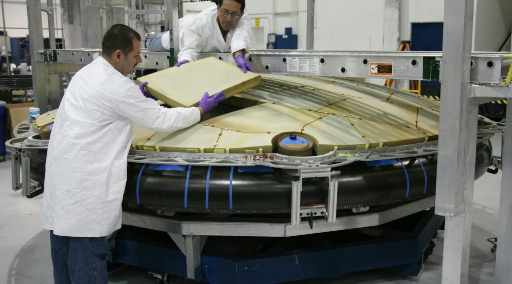 professional mechanics installing spaceship detail at factory