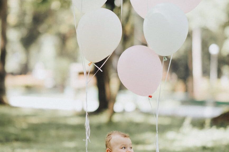 baby in basket with balloons