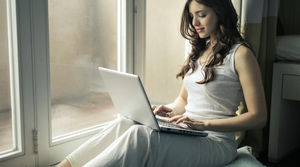 woman wearing tank top sitting by the window