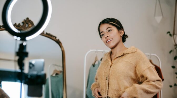 smiling ethnic woman recording video on smartphone