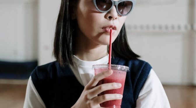 schoolgirl drinking smoothie in school gym